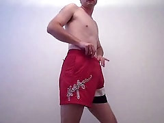 Handsome guy in red shorts playing with his hard cock and stroking